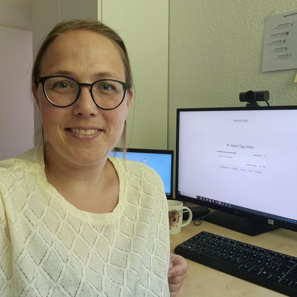 Linda Müller am Schreibtisch mit zwei Bildschirmen