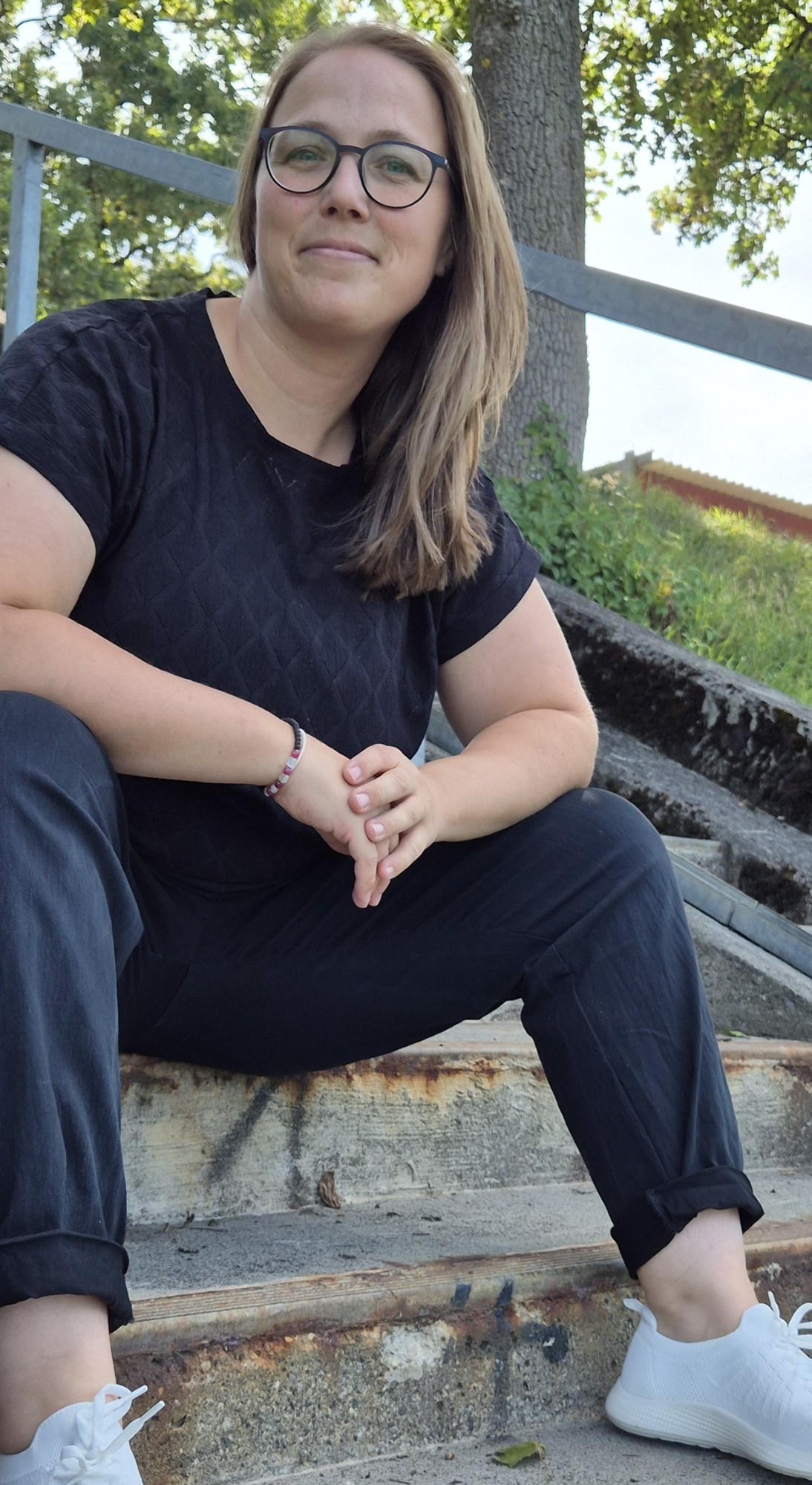 Linda Müller im Portrait auf einer Treppe im Freien