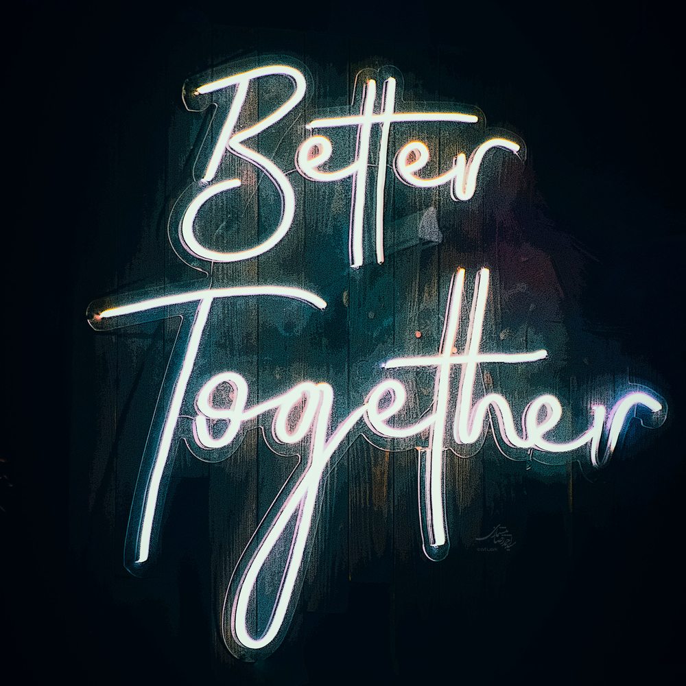 Leuchtschrift „Better Together“ an einer Holzwand